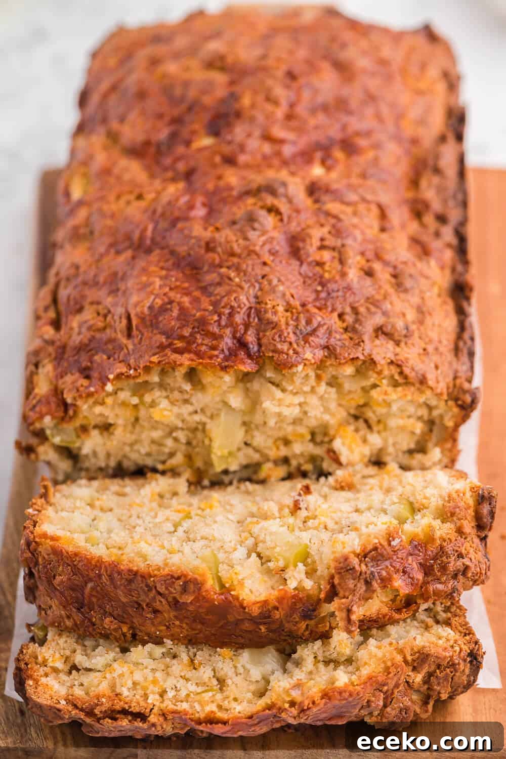 A loaf of apple cheddar bread with slices cut on the end