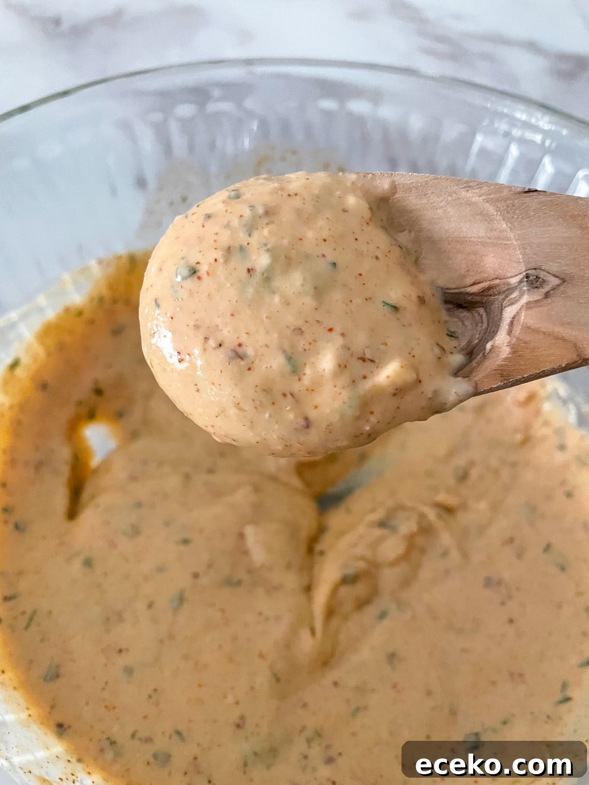 Authentic New Orleans Remoulade Sauce Recipe for Seafood 5 New Orleans remoulade sauce on a wooden spoon.
