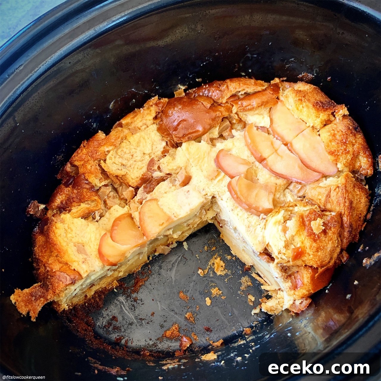 cooked Slow Cooker Apples & Honey Challah Bread Pudding in the slow cooker with a piece missing