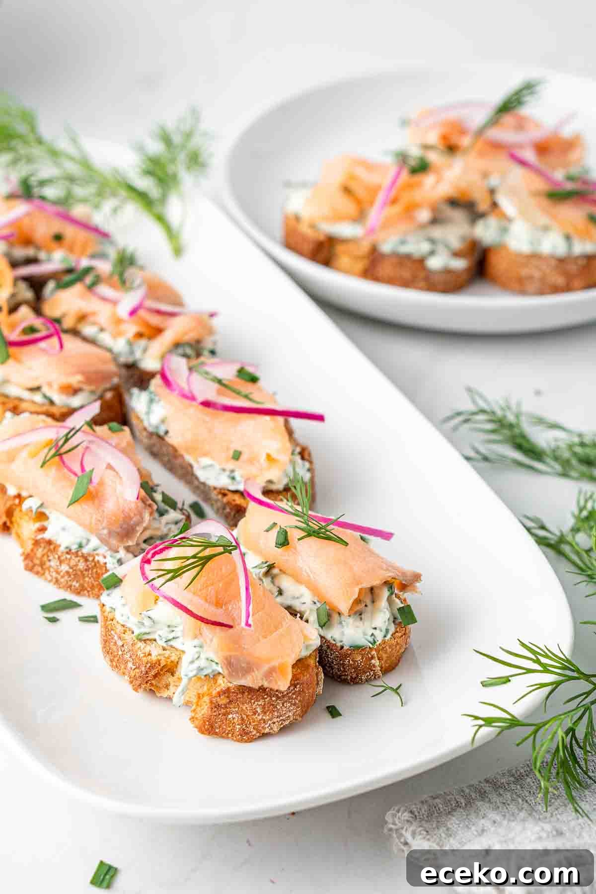 Smoked Salmon Crostini Recipe with Dill Cream Cheese & Capers 3 Smoked salmon crostini served on a white platter.