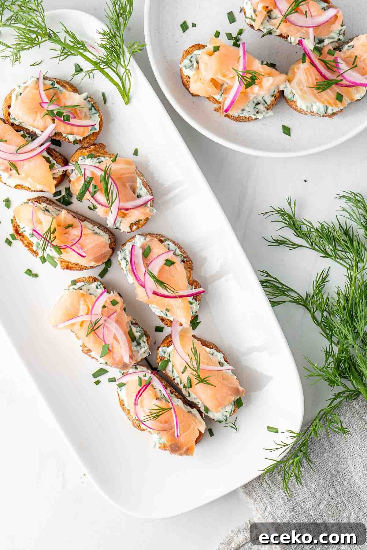 Smoked Salmon Crostini Recipe with Dill Cream Cheese & Capers 5 Smoked salmon crostini served on a long white platter from above.