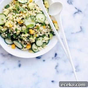 Israeli couscous salad on a plate with spoons