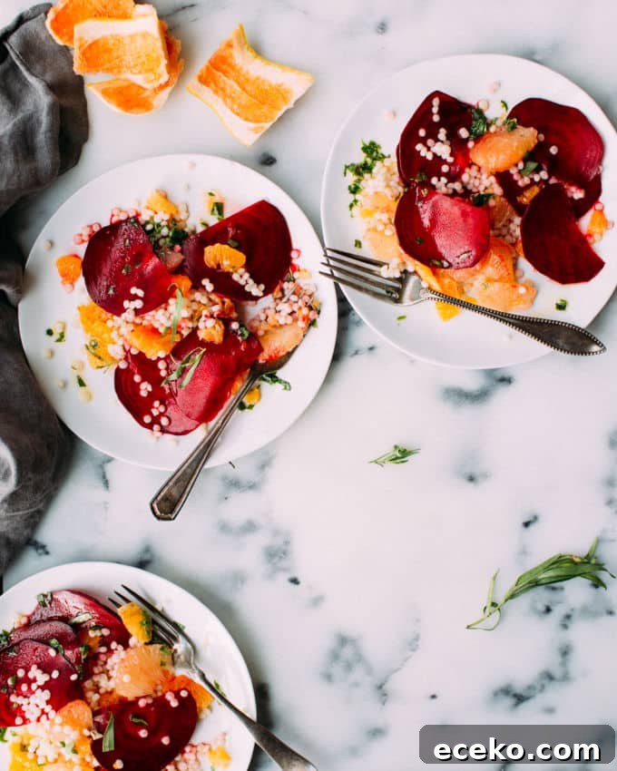Israeli couscous salad with beets and oranges on a plate.