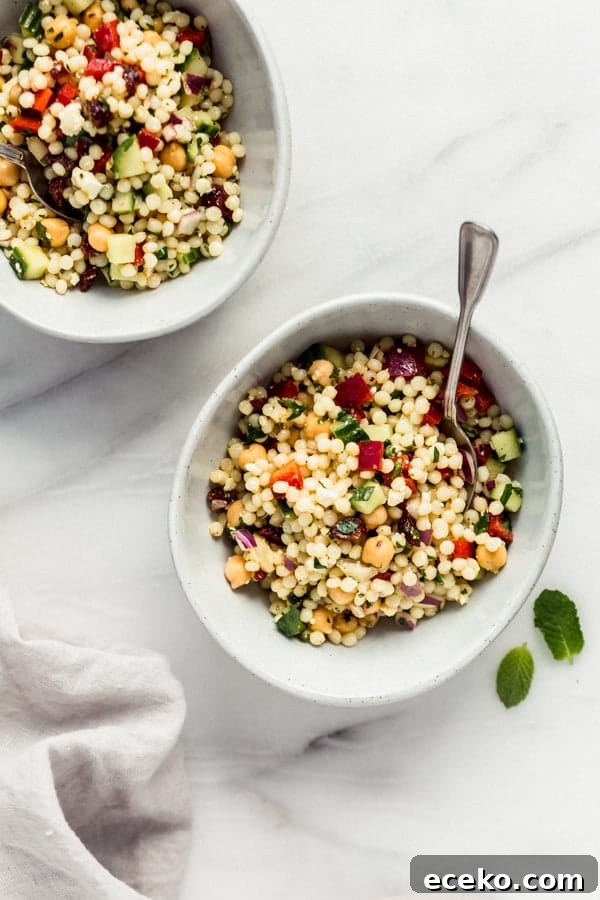 Israeli couscous salad with chickpeas and avocado on a plate.