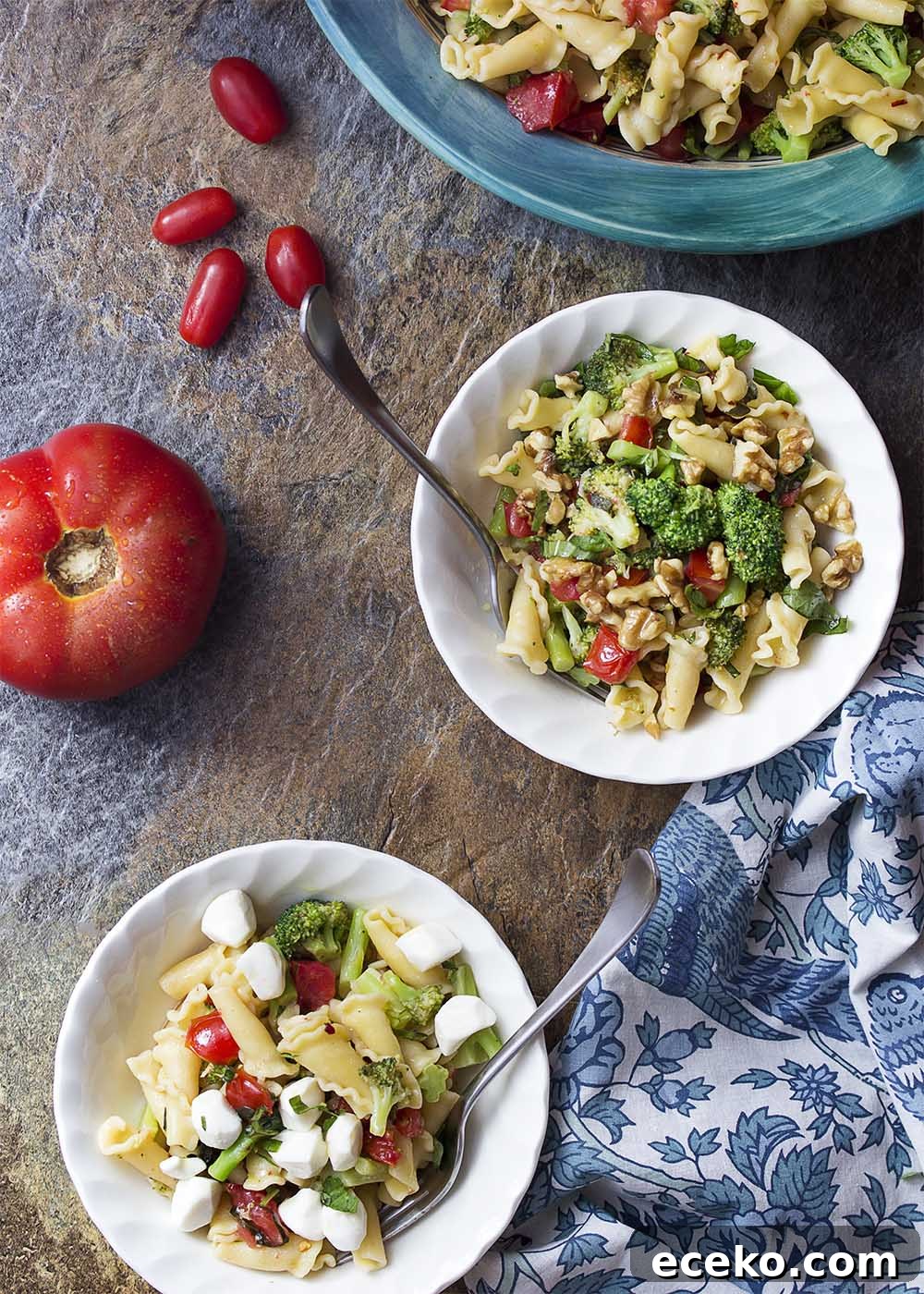 Two bowls of vegetarian pasta, one topped with mozzarella and the other topped with walnuts.