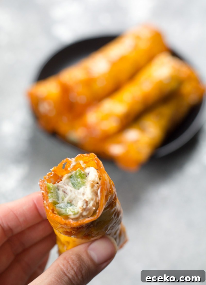 Keto Jalapeño Popper Taquitos with Crispy Bacon 3 a Jalapeño Popper Keto Taquito being held aloft
