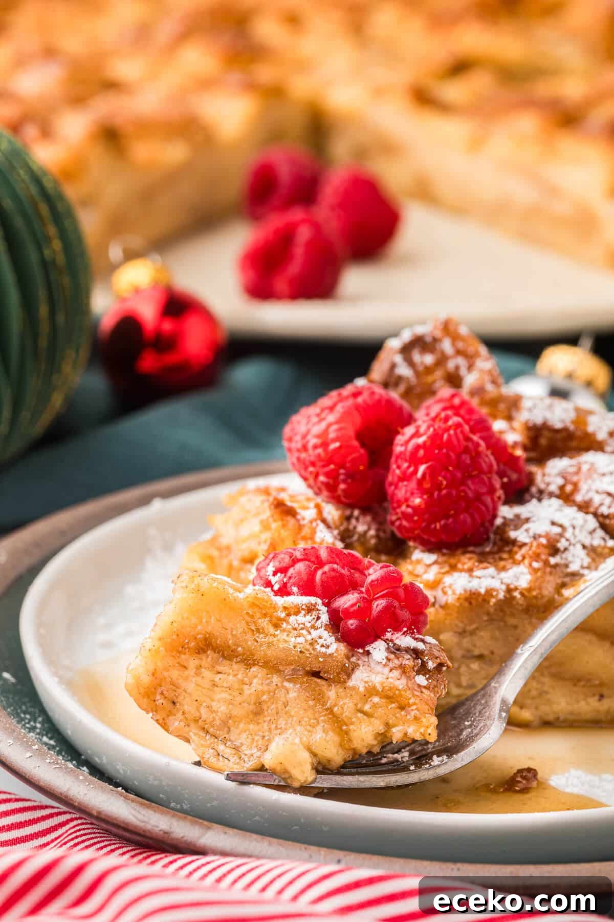 Eggnog Bread Pudding with Cinnamon-Caramel Sauce 7 A slice of eggnog bread pudding on a plate with a fork.