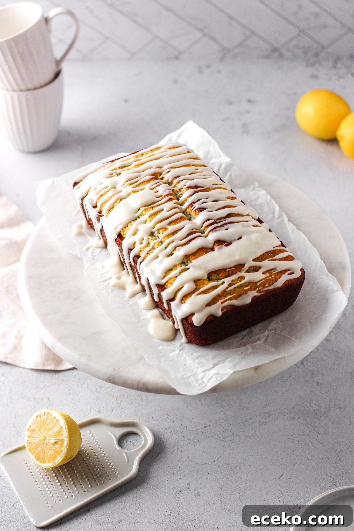 Moist Lemon Pound Cake with Zesty Lemon Glaze 2 lemon loaf with white glaze and lemons for a baking blog recipe and food photography