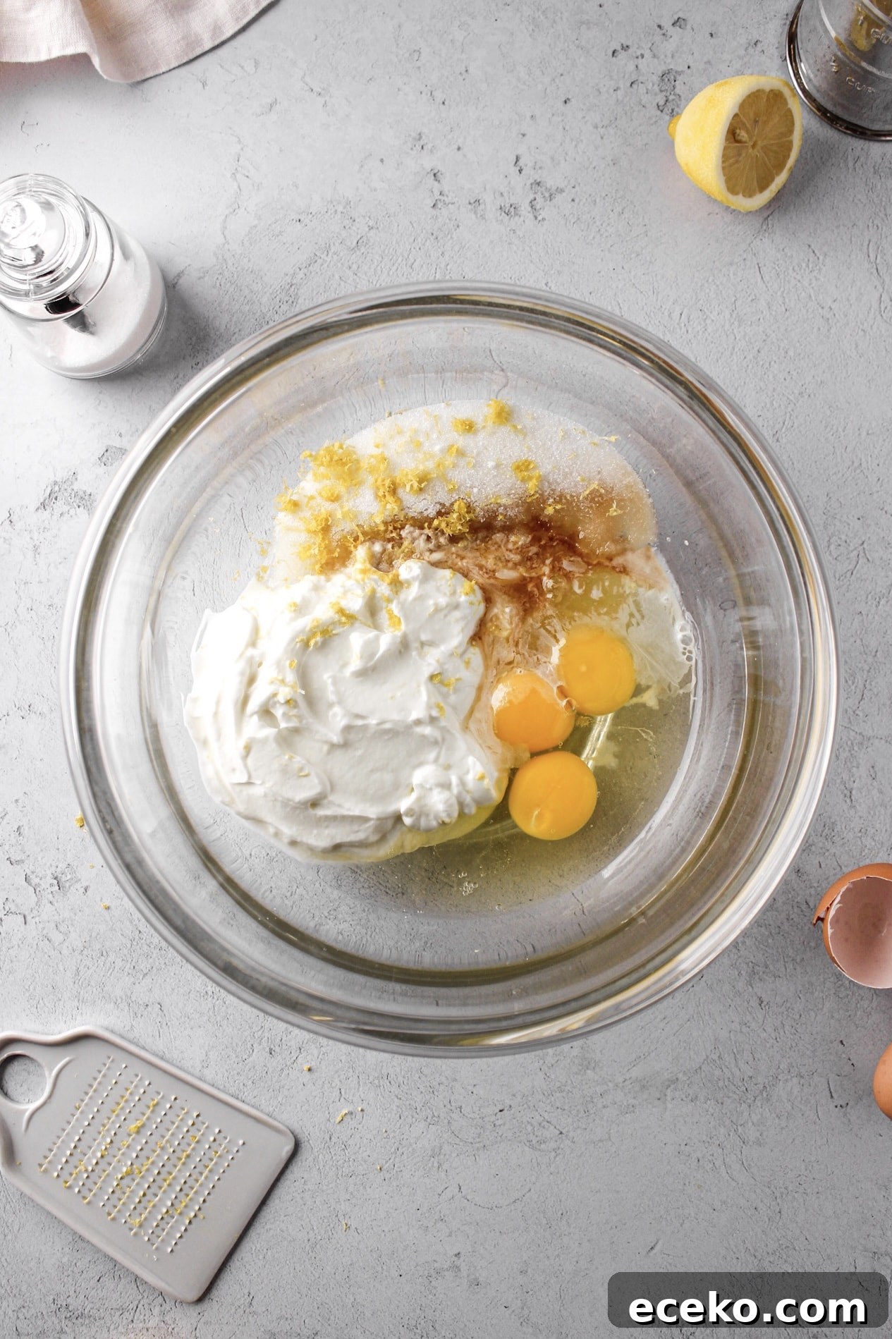 Moist Lemon Pound Cake with Zesty Lemon Glaze 4 glass bowl of lemon pound cake ingredients with lemons, yogurt and eggs