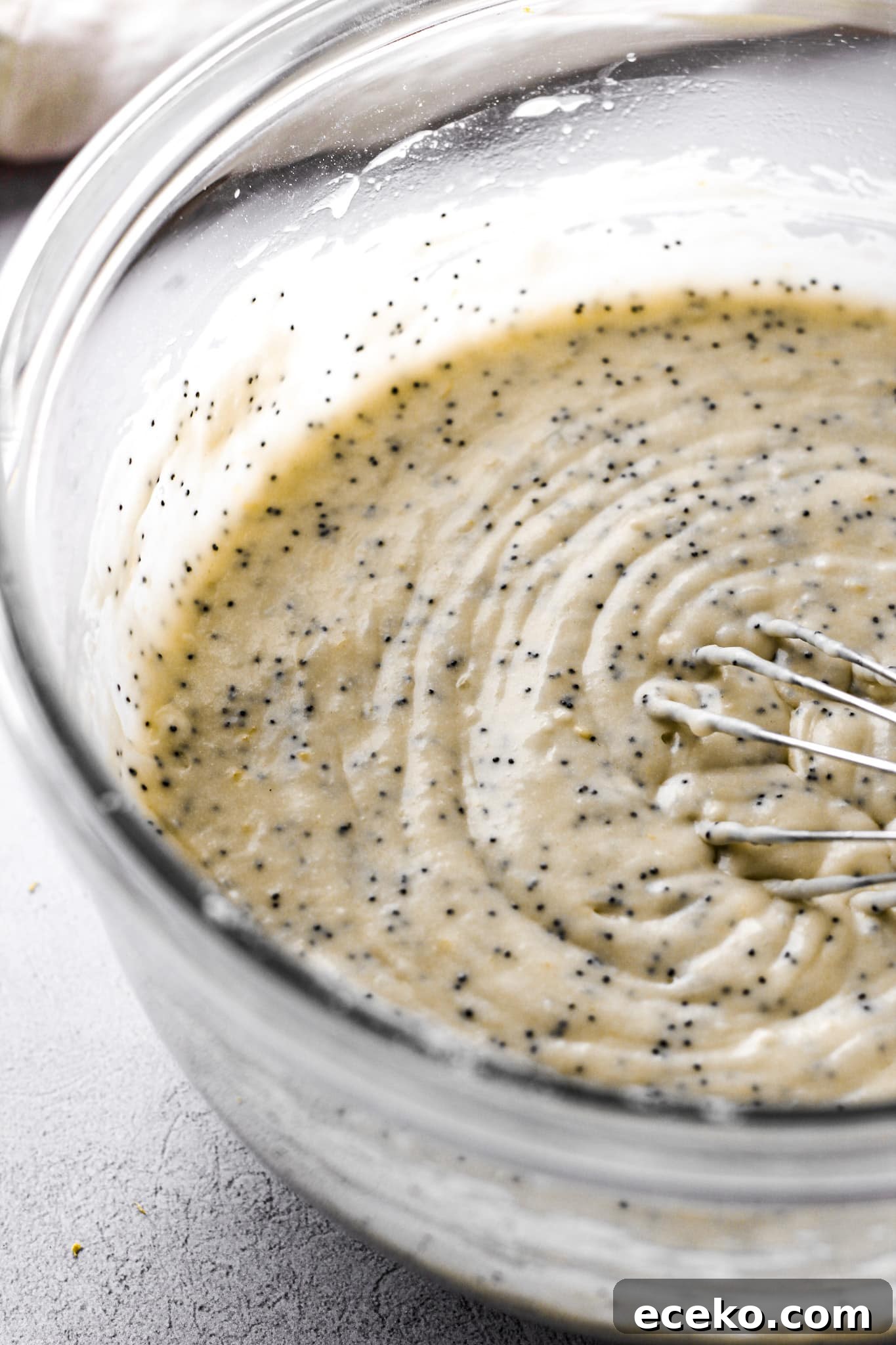 Moist Lemon Pound Cake with Zesty Lemon Glaze 5 lemon poppy seed cake batter with a whisk for baking blog and food photography