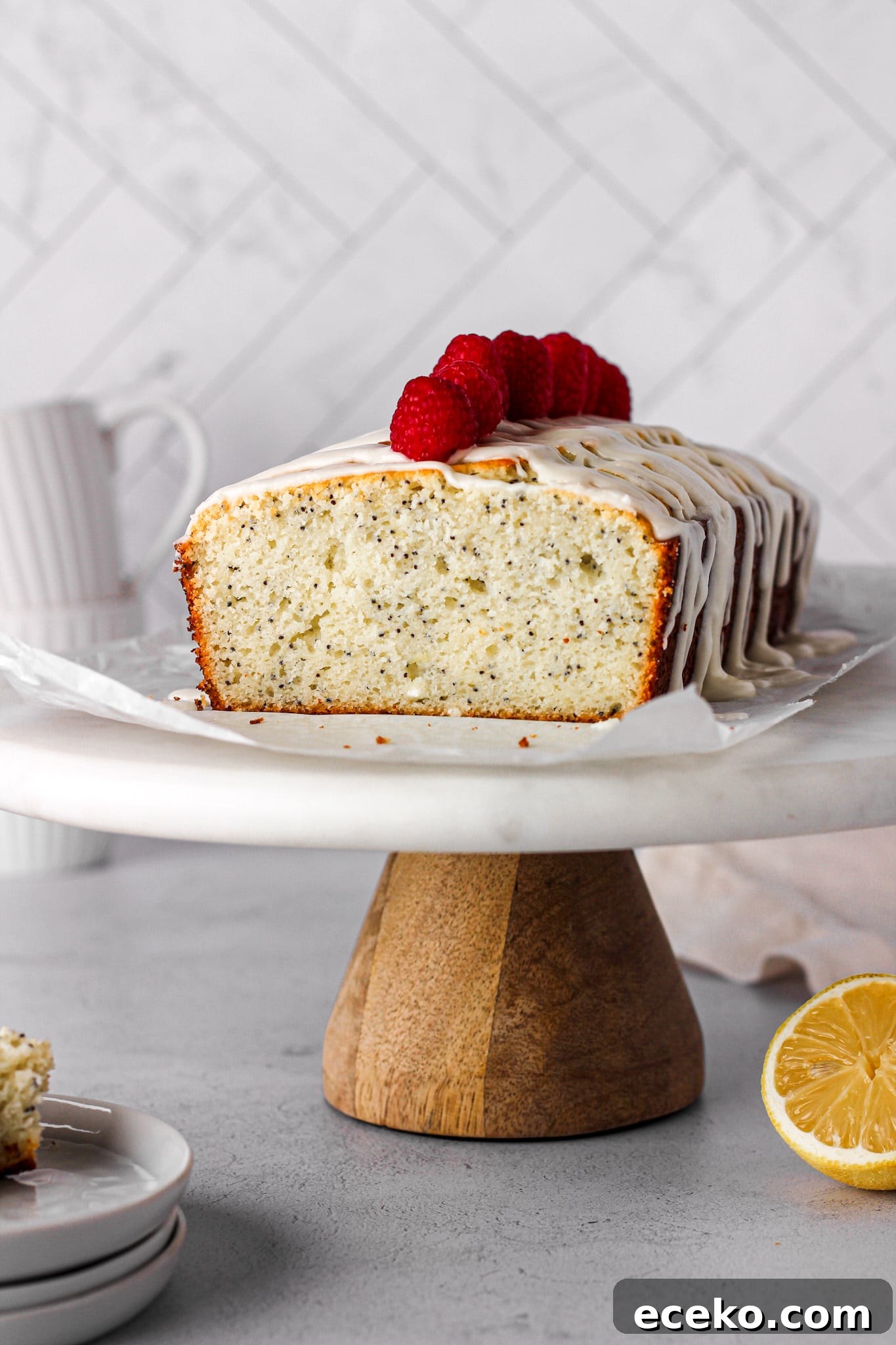 Moist Lemon Pound Cake with Zesty Lemon Glaze 7 lemon pound cake with raspberries on a marble cake stand for baking blog and food photography