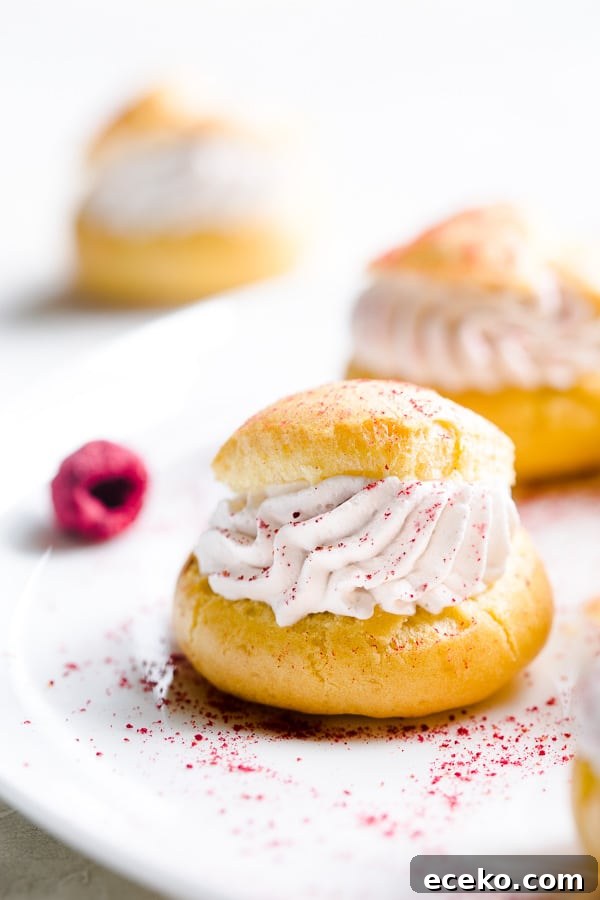 Raspberry Crème Puffs with Vanilla Cream Filling 3 Raspberry creme puffs on a plate.