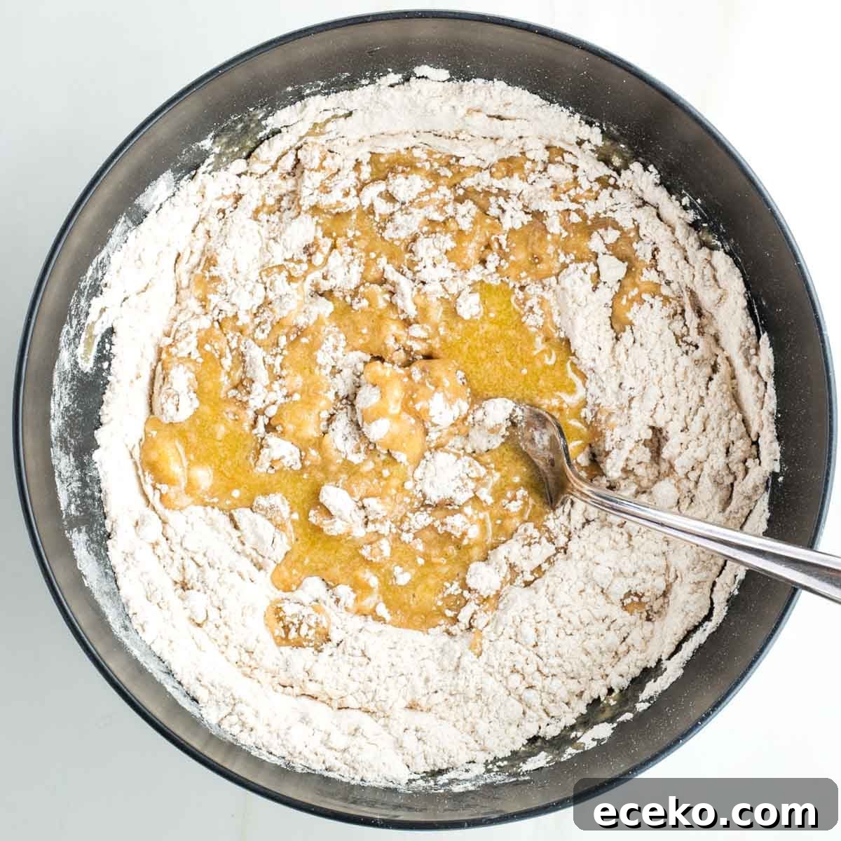 Vegan Apple Pie Bars with Cinnamon Streusel 8 Mixing yellow liquid into a flour mixture.