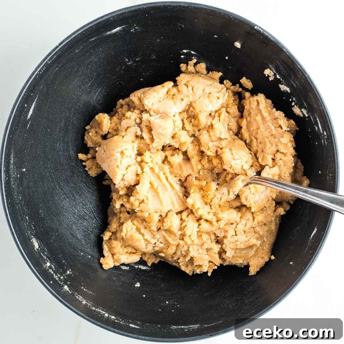 Vegan Apple Pie Bars with Cinnamon Streusel 9 Lumpy pie dough in a black bowl.
