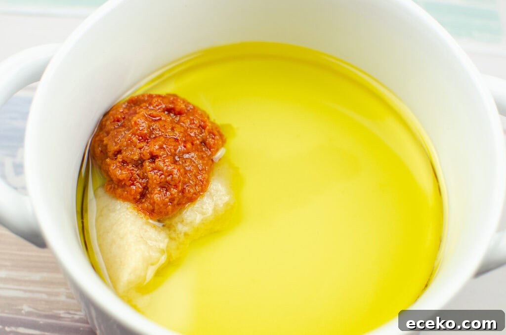 Olive and Herb Focaccia Bread Recipe 6 olive oil, garlic puree and sun dried tomato puree in a white bowl