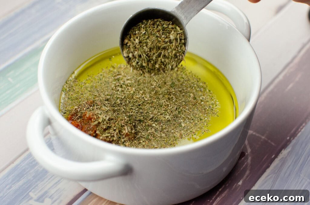 Olive and Herb Focaccia Bread Recipe 7 Dried mixed herbs being added to the olive oil mixture