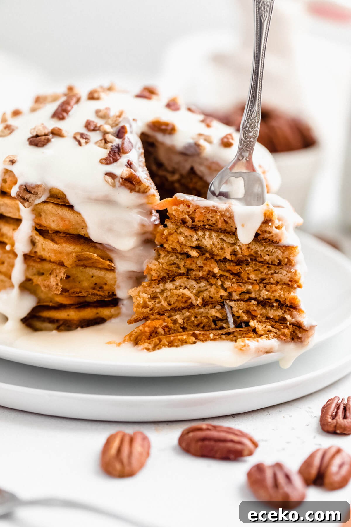 Carrot Cake Pancake Recipe with Cream Cheese Glaze 4 fork inside a stacked piece of pancakes