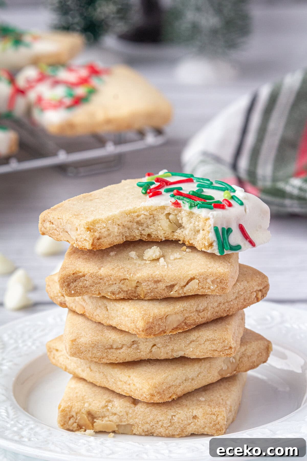 Hawaiian Shortbread Cookies with Coconut and Macadamia 2 Sprinkled Christmas Hawaiian shortbread cookies stacked on each other on a plate.