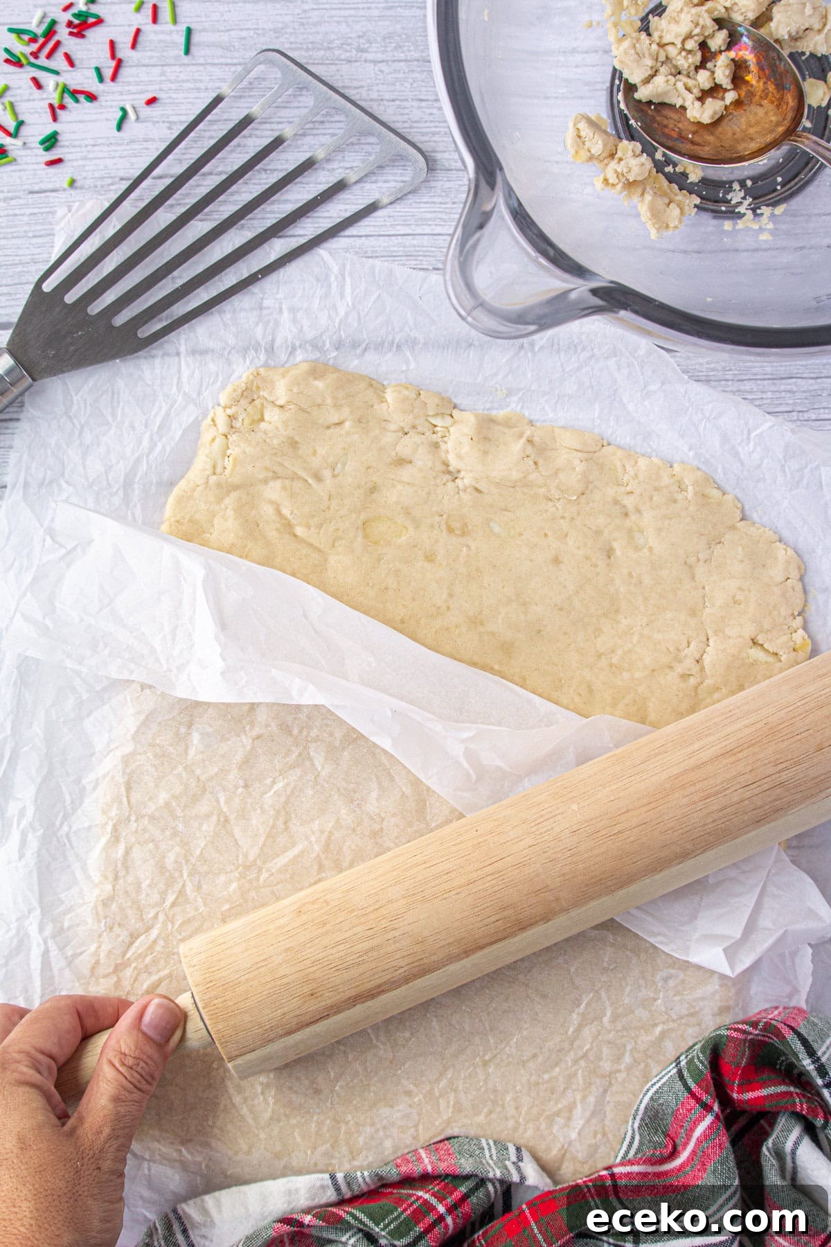 Hawaiian Shortbread Cookies with Coconut and Macadamia 5 Rolling out the shortbread dough between parchment papers sheets.
